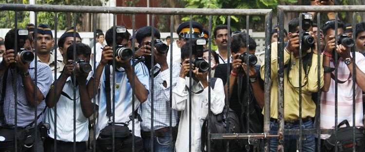 Indian press photographers stand behind a fence for security reasons as they take pictures of Belgium's Queen Paola in a school in Mumbai November 6, 2008. Belgium's King Albert II and Queen Paola are on a official state visit to India.     REUTERS/Francois Lenoir   (INDIA)