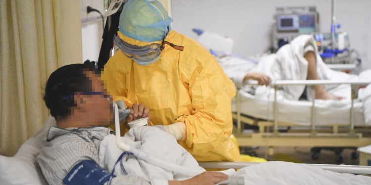(200201) -- CHONGQING, Feb. 1, 2020 (Xinhua) -- A medical worker helps a patient drink water at an isolation ward at a hospital in southwest China's Chongqing, Feb. 1, 2020. Designated as one of the four hospitals for the treatment of pneumonia caused by the novel coronavirus in Chongqing, the Chongqing Three Gorges Central Hospital has organized a total of 480 beds and nearly 500 medical workers to combat the disease. (Xinhua/Wang Quanchao)